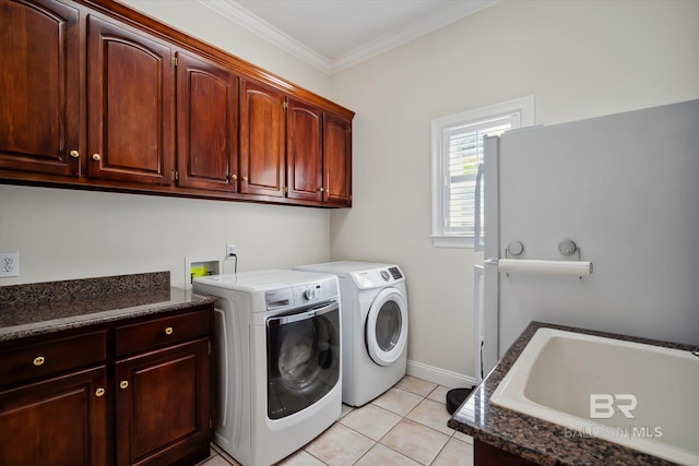 laundry area featuring separate washer and dryer, sink, cabinets, light tile patterned floors, and crown molding