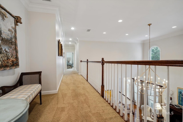 hallway with a notable chandelier, crown molding, and light colored carpet