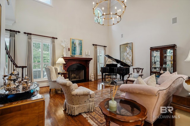 living room featuring a high ceiling, dark hardwood / wood-style floors, and an inviting chandelier