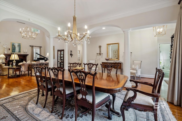 dining area featuring hardwood / wood-style flooring, a chandelier, and ornate columns