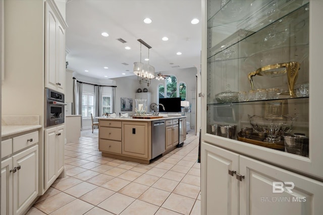 kitchen with light tile patterned flooring, a kitchen island, white cabinets, hanging light fixtures, and stainless steel appliances