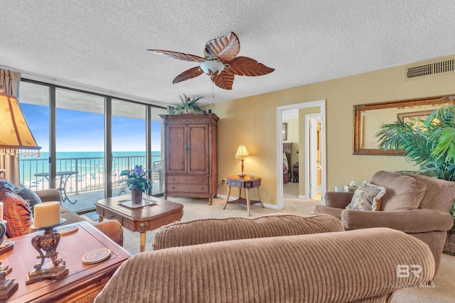 24522 Perdido Beach Blvd Unit 5617, Orange Beach, AL 36561 - living room with light carpet, ceiling fan, a water view, a wall of windows, and a textured ceiling