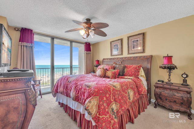 24522 Perdido Beach Blvd Unit 5617, Orange Beach, AL 36561 - carpeted bedroom featuring access to exterior, view of water and beach, a textured ceiling, and a ceiling fan