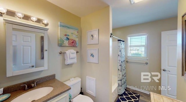 full bathroom featuring toilet, vanity, shower / tub combo with curtain, and hardwood / wood-style flooring