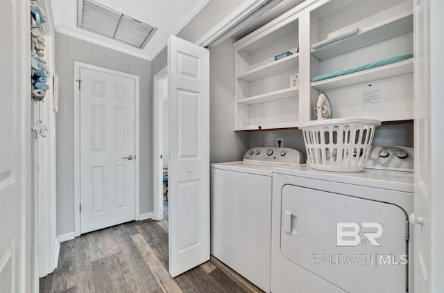 laundry area with washer and dryer, ornamental molding, and hardwood / wood-style floors