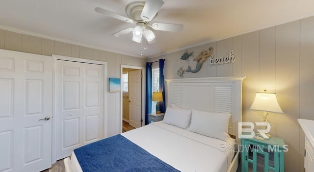 bedroom with ceiling fan, a closet, hardwood / wood-style flooring, and crown molding