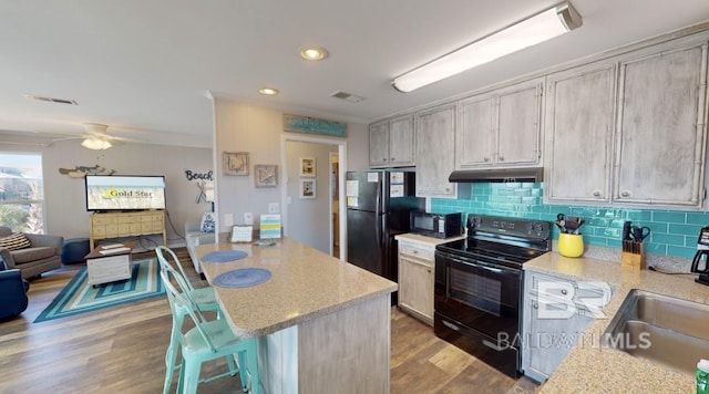 kitchen featuring ceiling fan, decorative backsplash, black appliances, light hardwood / wood-style flooring, and sink