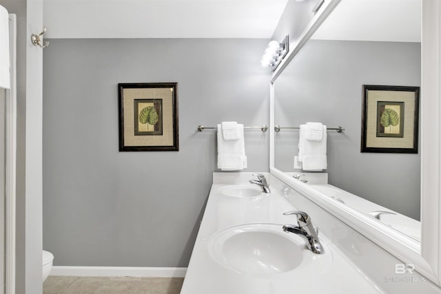 bathroom with baseboards, a sink, toilet, and tile patterned floors