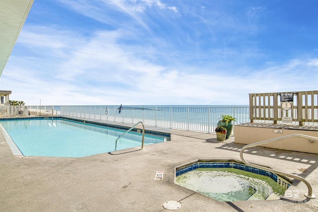 community pool featuring a community hot tub, a patio area, and a water view