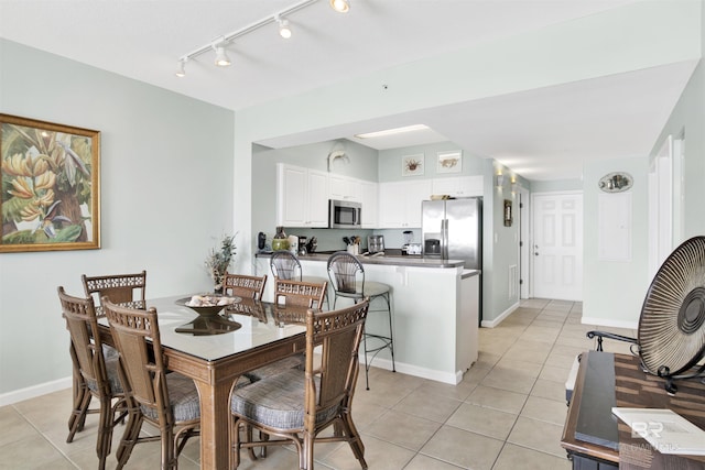 dining space featuring baseboards and light tile patterned floors