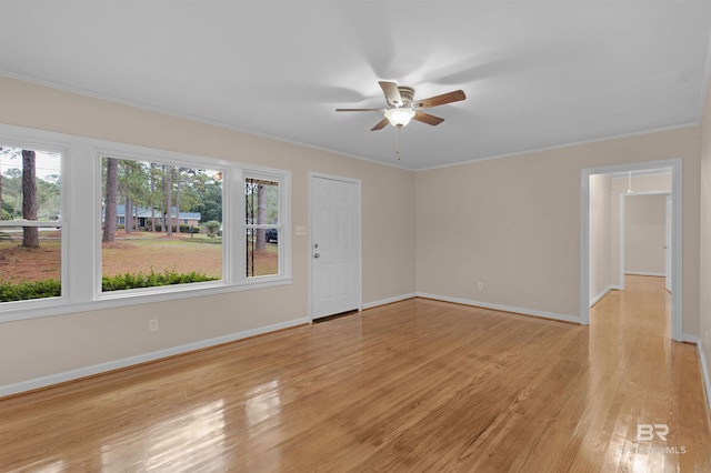 empty room with a wealth of natural light, light hardwood / wood-style floors, and crown molding