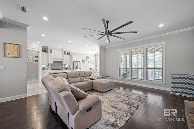 living area with dark wood-style flooring, visible vents, and crown molding