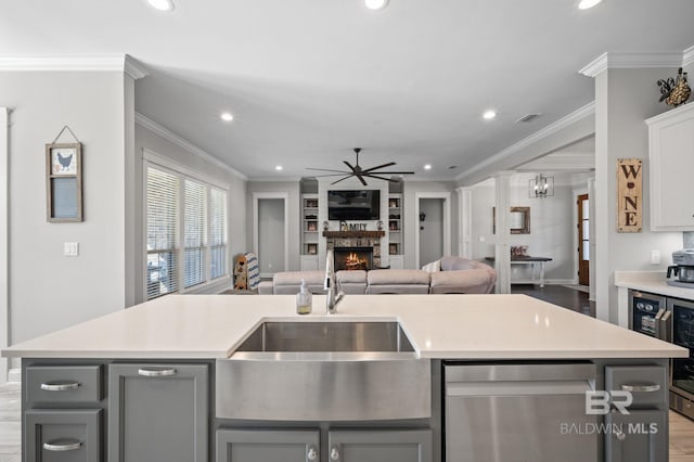 kitchen with a large fireplace, gray cabinets, a sink, and open floor plan