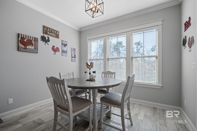 dining area with baseboards, a notable chandelier, and crown molding