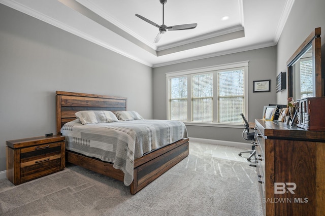 carpeted bedroom featuring ceiling fan, ornamental molding, a raised ceiling, and baseboards