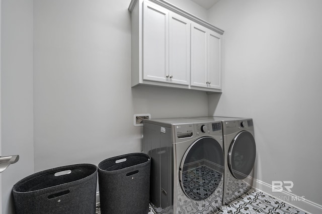 laundry area with washing machine and dryer, cabinet space, and baseboards