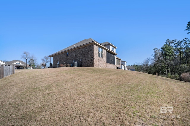 view of side of home featuring brick siding and a lawn