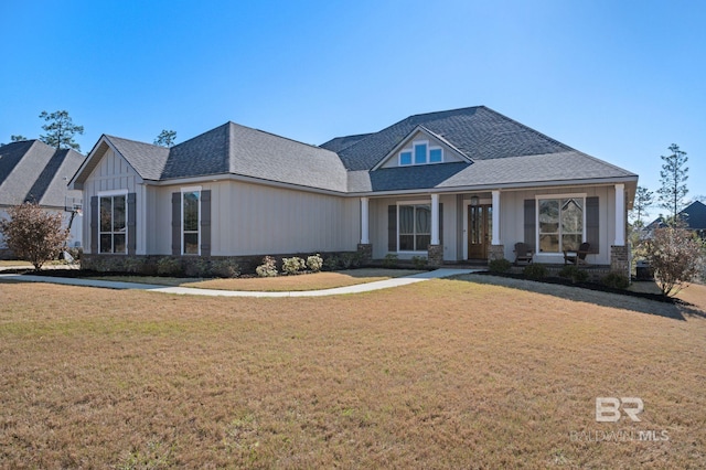 view of front of house featuring a shingled roof, board and batten siding, and a front yard