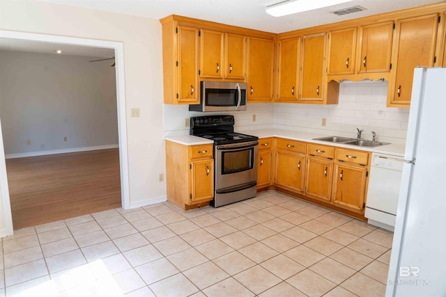 kitchen featuring visible vents, appliances with stainless steel finishes, a sink, light countertops, and backsplash