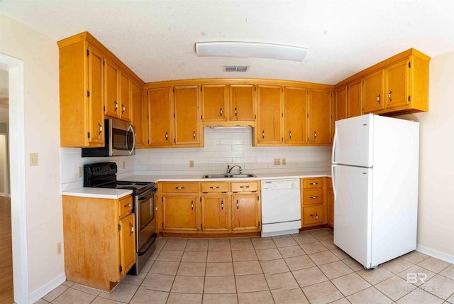 kitchen featuring light tile patterned flooring, white appliances, a sink, visible vents, and tasteful backsplash