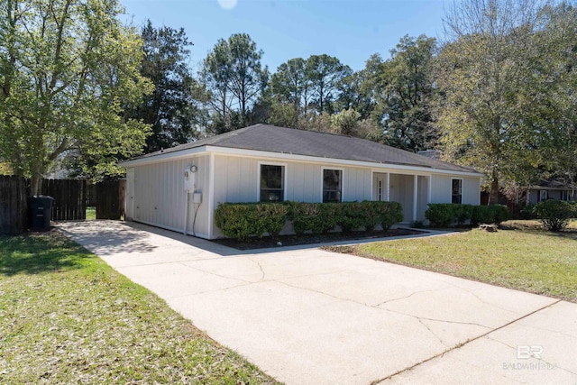 single story home with concrete driveway, fence, and a front lawn