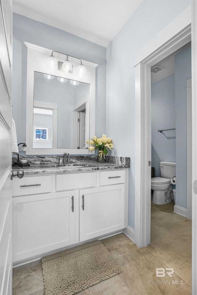 bathroom featuring vanity and toilet