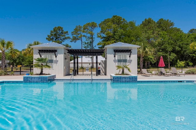 view of pool with a patio area, pool water feature, and an outdoor structure