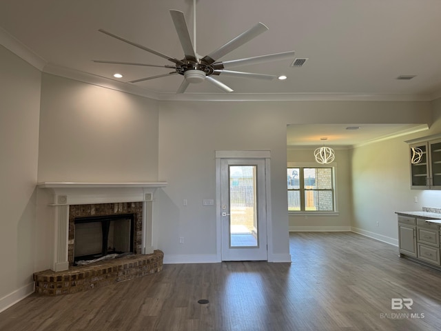 unfurnished living room with crown molding, ceiling fan, hardwood / wood-style floors, and a brick fireplace