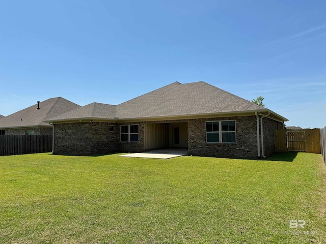 back of house with a patio and a lawn