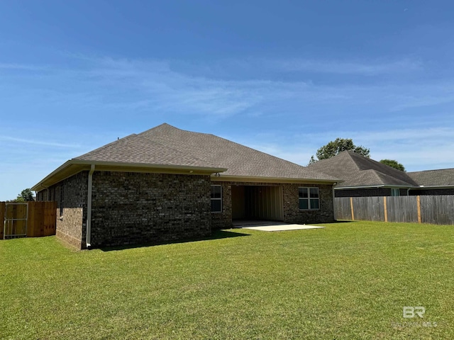 rear view of property featuring a patio and a lawn