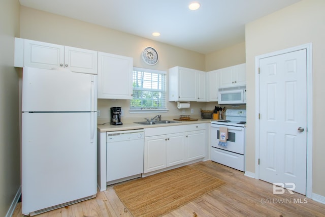 kitchen featuring white appliances, a sink, white cabinetry, light countertops, and light wood finished floors