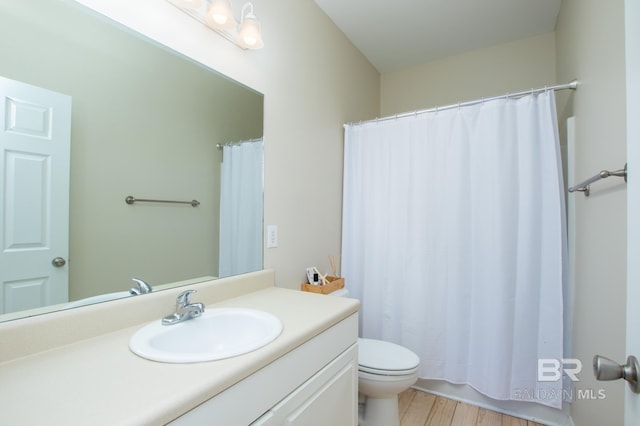 bathroom with a shower with shower curtain, vanity, toilet, and wood finished floors