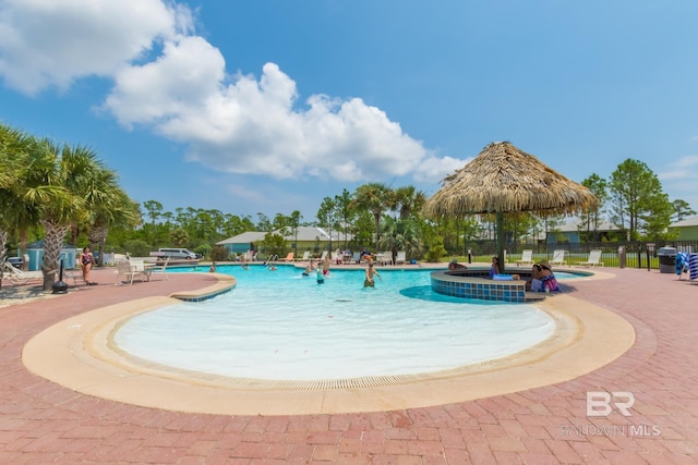 community pool featuring fence and a patio