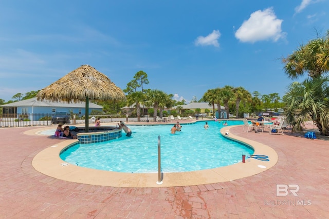 community pool with fence and a patio