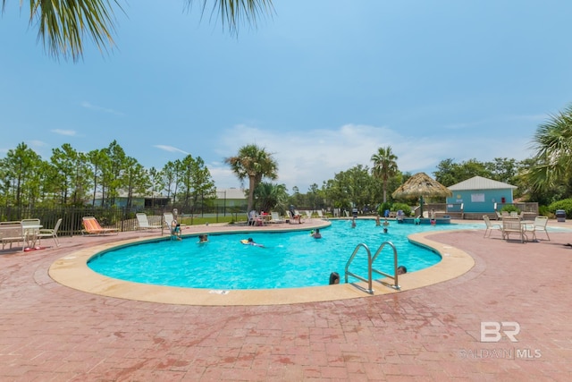 community pool featuring fence and a patio