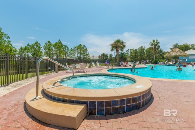 pool featuring fence, a community hot tub, and a patio