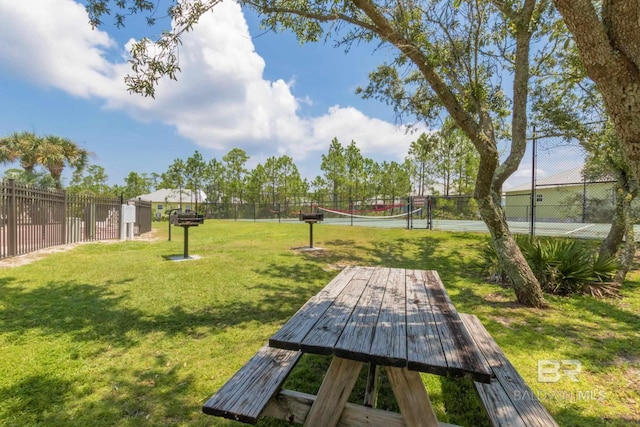 view of property's community with fence and a yard