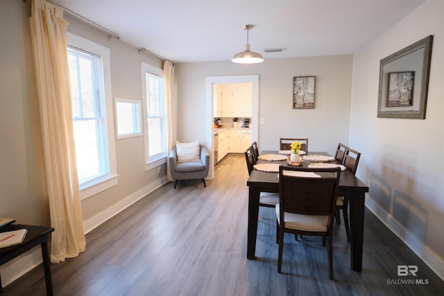 dining room with hardwood / wood-style floors and a healthy amount of sunlight