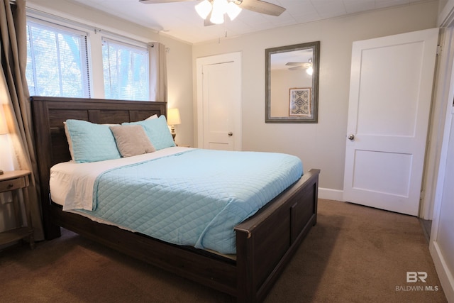 bedroom featuring ceiling fan and dark colored carpet