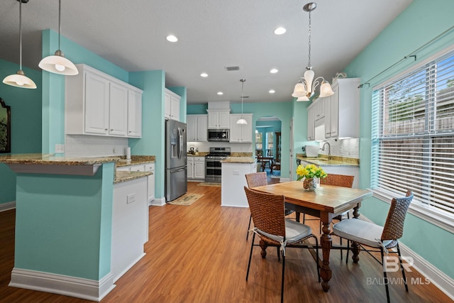 2554 Masters Ct, Mobile, AL 36618 - dining area with arched walkways, light wood finished floors, and recessed lighting