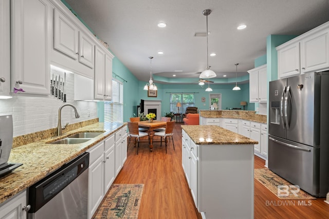 2554 Masters Ct, Mobile, AL 36618 - kitchen featuring stainless steel appliances, a fireplace, a ceiling fan, recessed lighting, and white cabinetry