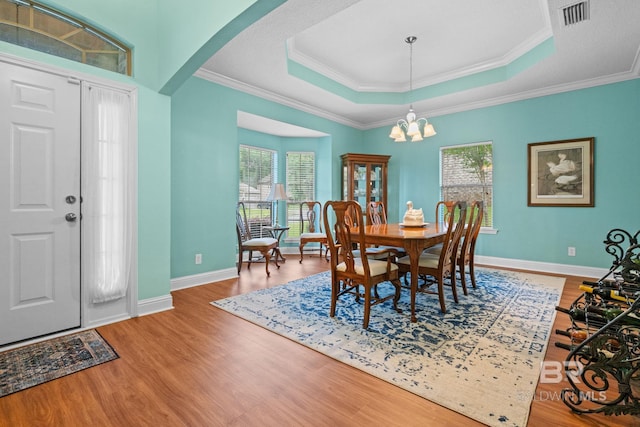 2554 Masters Ct, Mobile, AL 36618 - dining area featuring a raised ceiling, arched walkways, wood finished floors, a chandelier, and crown molding