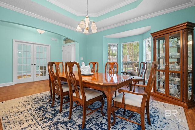 2554 Masters Ct, Mobile, AL 36618 - dining space featuring wood finished floors, a chandelier, a tray ceiling, crown molding, and french doors