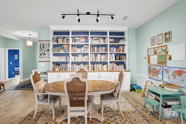 dining room with track lighting and light hardwood / wood-style floors