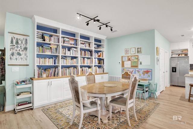 dining area featuring track lighting and light wood-type flooring