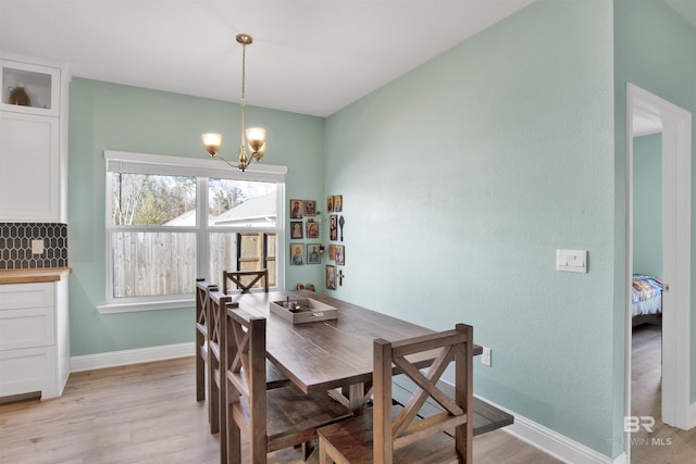 dining space with an inviting chandelier and light hardwood / wood-style flooring