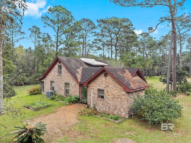 view of side of property featuring a lawn and central AC unit