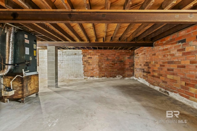 basement with heating unit and brick wall