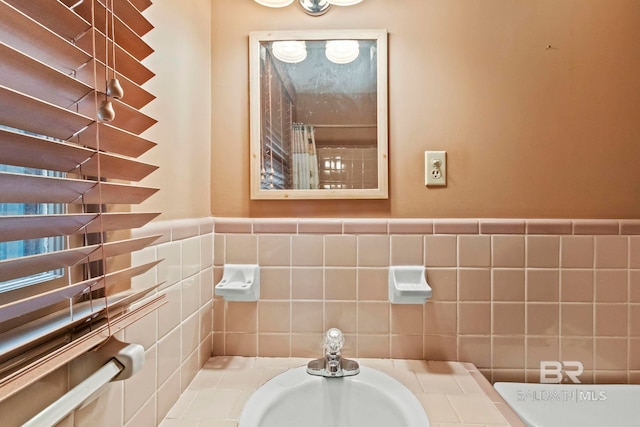 bathroom with sink and tile walls