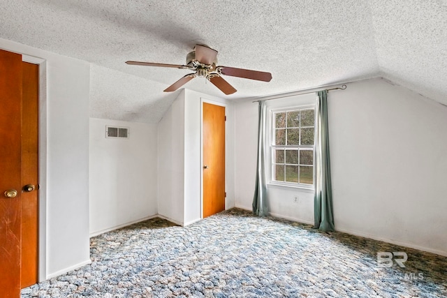 bonus room featuring ceiling fan, lofted ceiling, a textured ceiling, and carpet floors